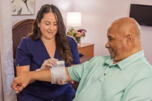 a nurse wrapping a wound on the arm of a resident at La Mesa facility